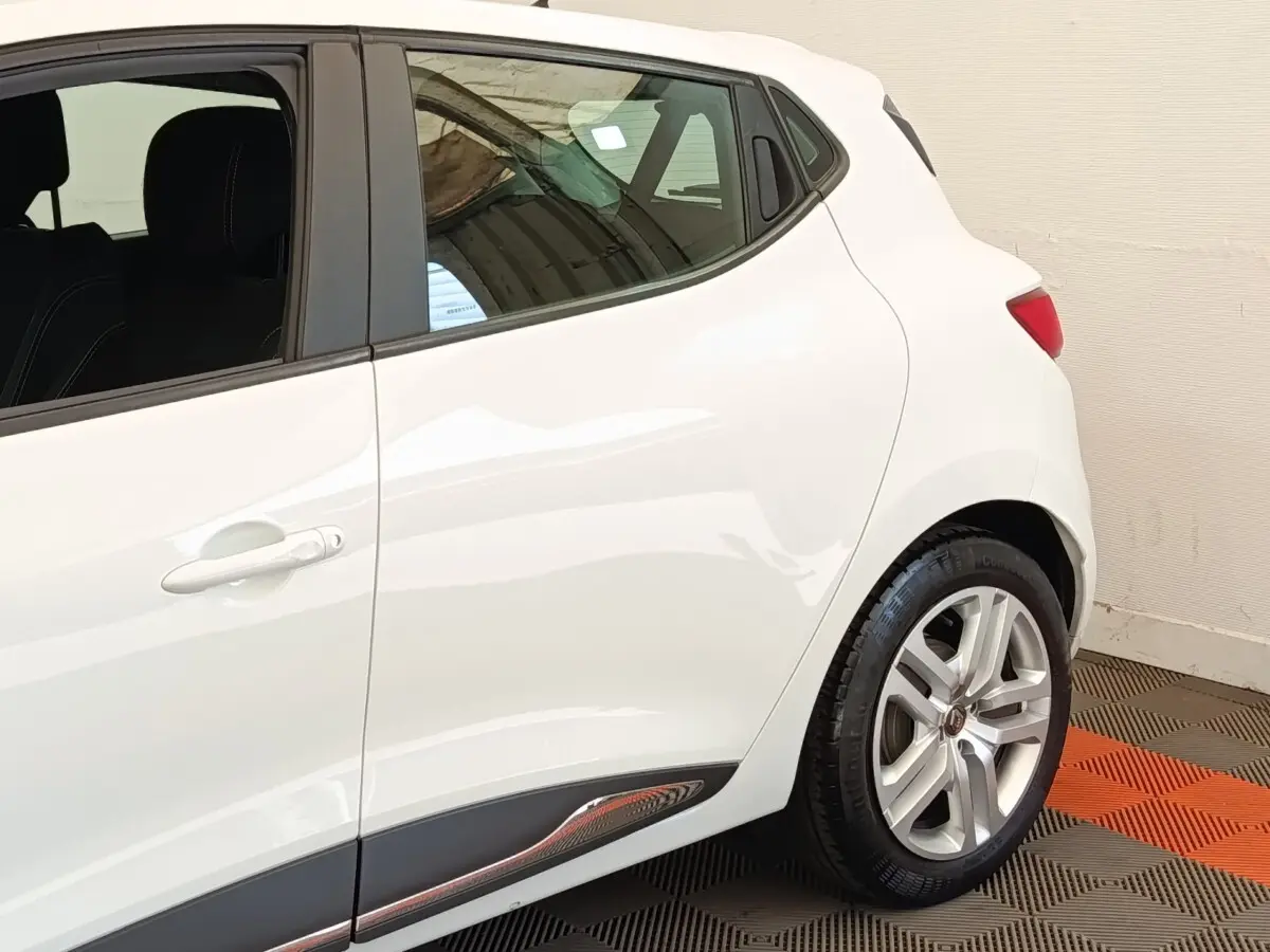 Vue latérale arrière droite d'une Renault Clio Business dCi 75 blanche avec jante alliage et poignées de porte intégrées.