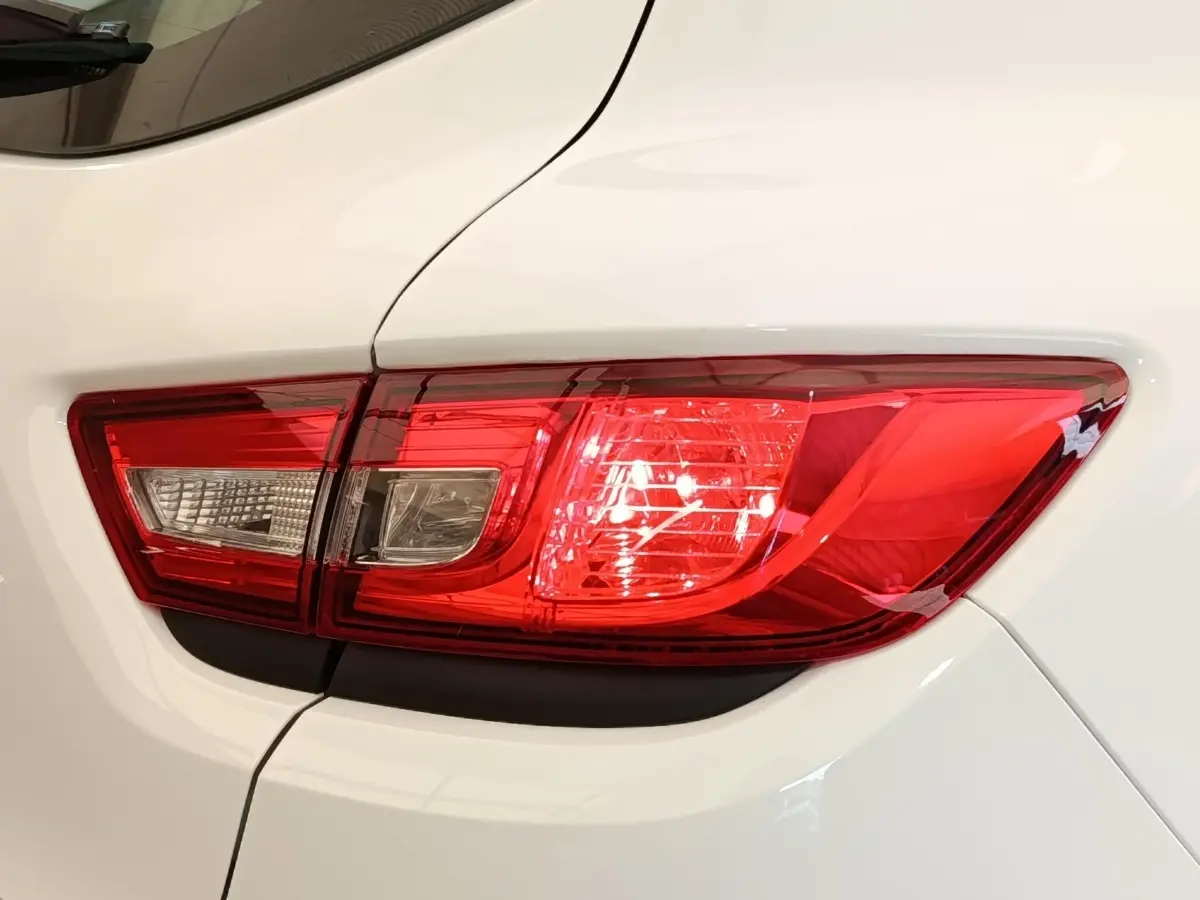 Gros plan sur le feu arrière droit rouge et blanc d’une Renault Clio Business dCi 75 blanche de 2018.