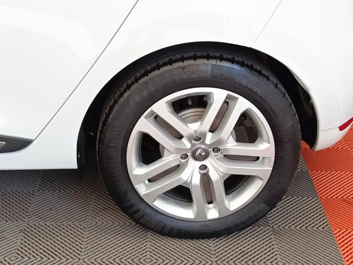 Gros plan sur la roue arrière droite d’une Renault Clio Business dCi 75 blanche, avec jante alliage et logo Renault visible.