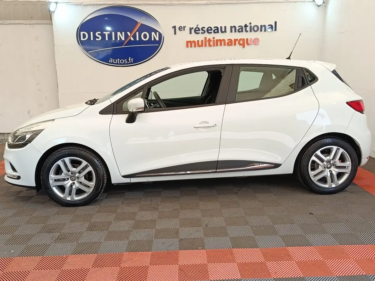 Profil côté gauche d'une Renault Clio Business dCi 75 blanche de 2018, avec jantes alliage et rétroviseurs blancs.