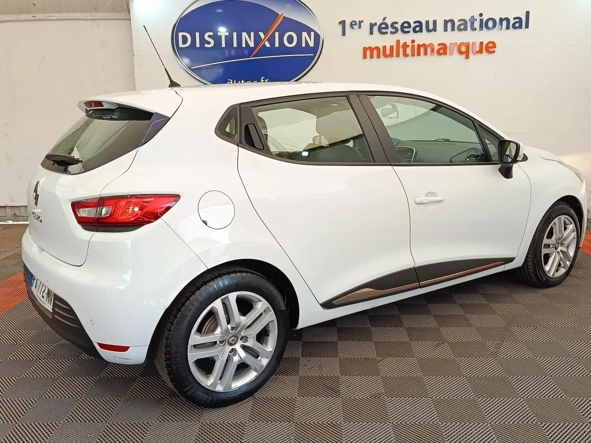 Renault Clio Business dCi 75 blanc vue 3/4 arrière droit, jantes alliage et feux arrière allumés.