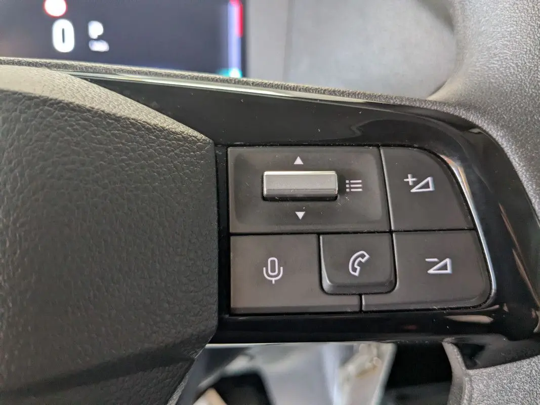 Gros plan sur les commandes noires du volant du Fiat Scudo Fourgon blanc, version 2025, avec boutons de volume et appel.