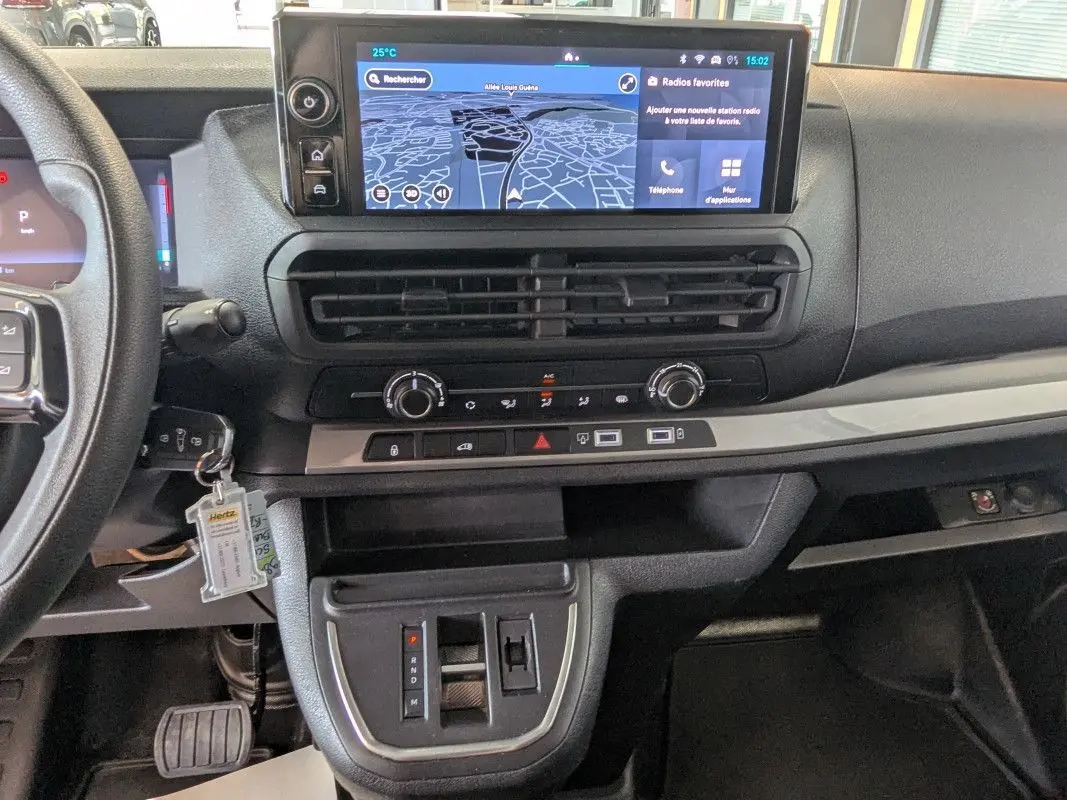Vue intérieure du tableau de bord du Fiat Scudo Fourgon blanc 2025, avec écran tactile GPS et commandes climatisation visibles.
