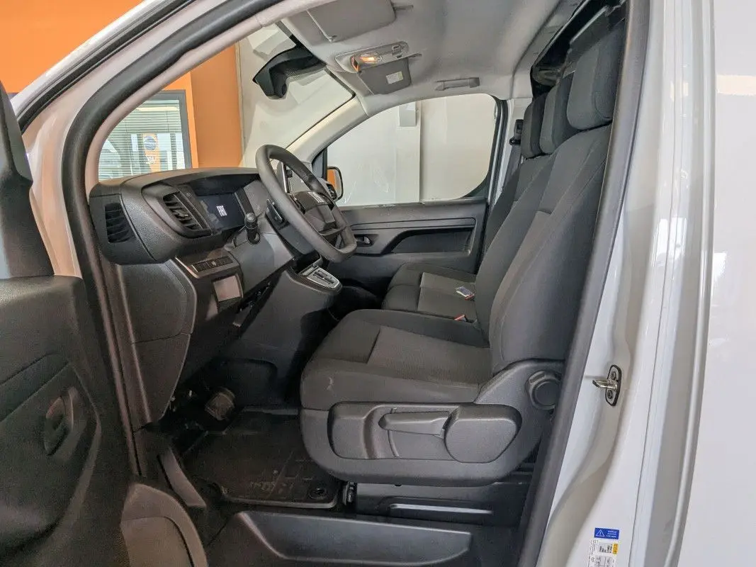 Vue intérieure côté conducteur du Fiat Scudo Fourgon blanc 2025, montrant les sièges modulables et le tableau de bord.