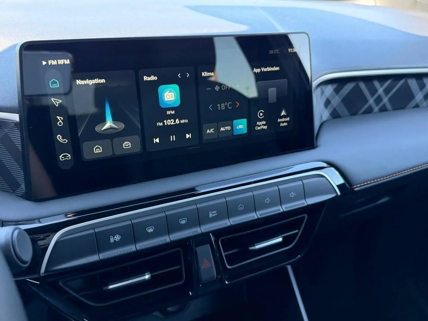 Vue rapprochée de la console centrale du MG3 1.5 Hybrid+ 2026 avec écran tactile et commandes climatisation, finition noire.