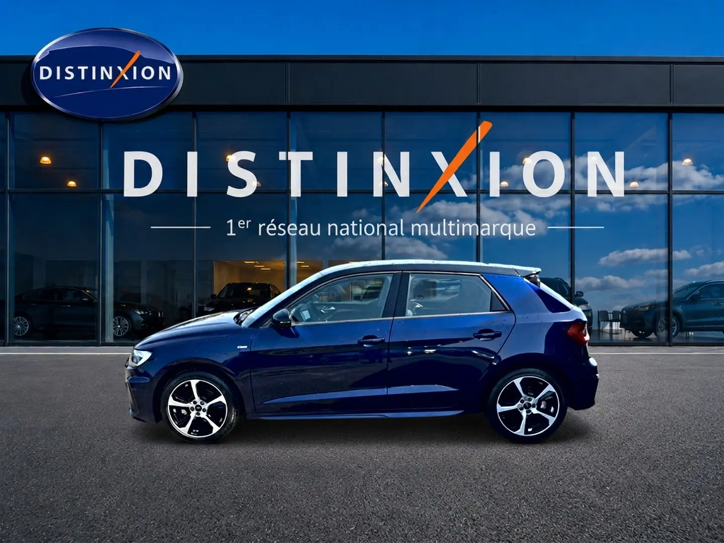 Audi A1 Sportback 30 TFSI bleu foncé vue de profil côté gauche devant une vitrine avec logo Distinxion.