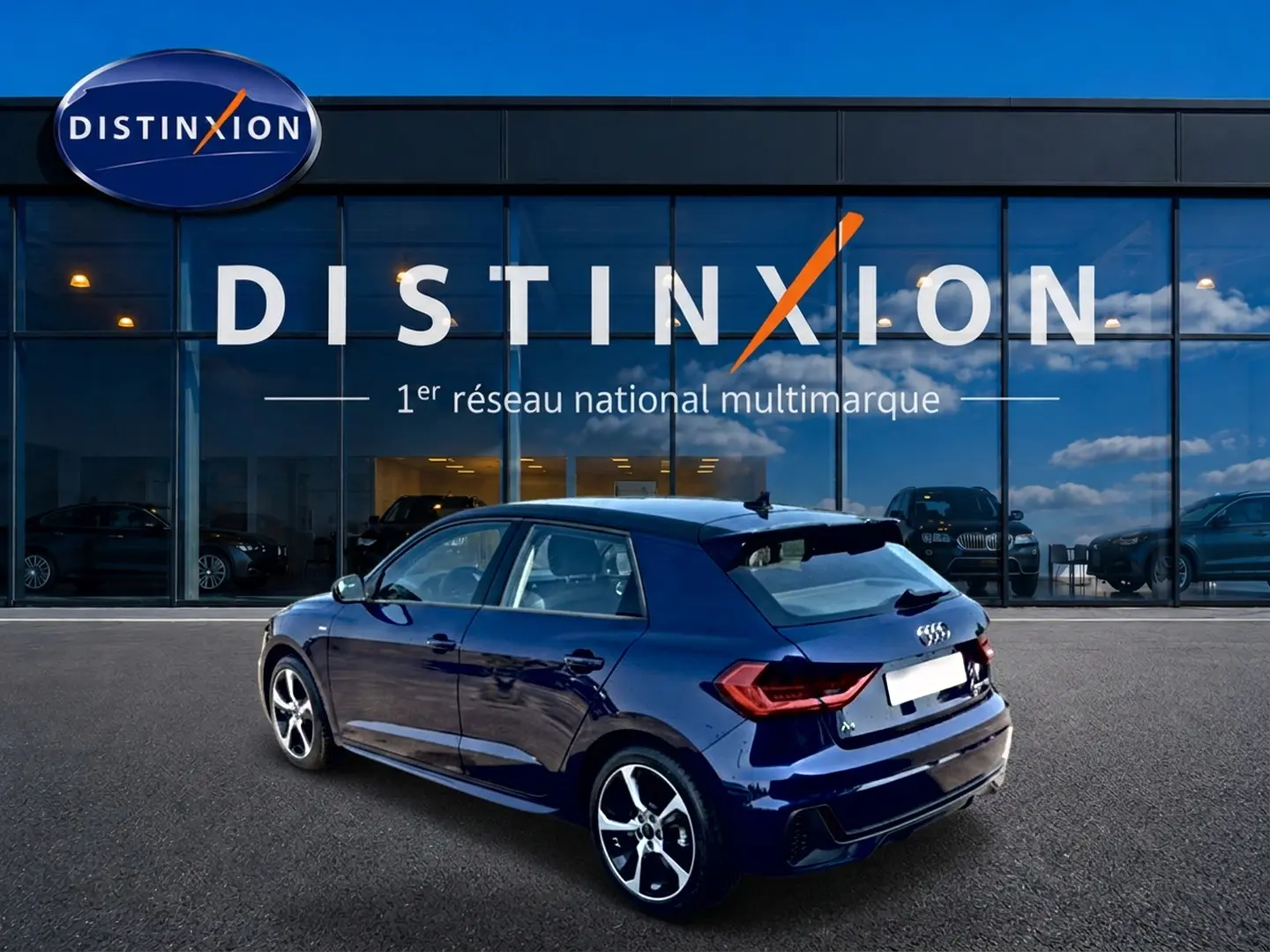 Audi A1 Sportback bleu foncé vue 3/4 arrière droit, avec jantes alliage et becquet arrière sportif.