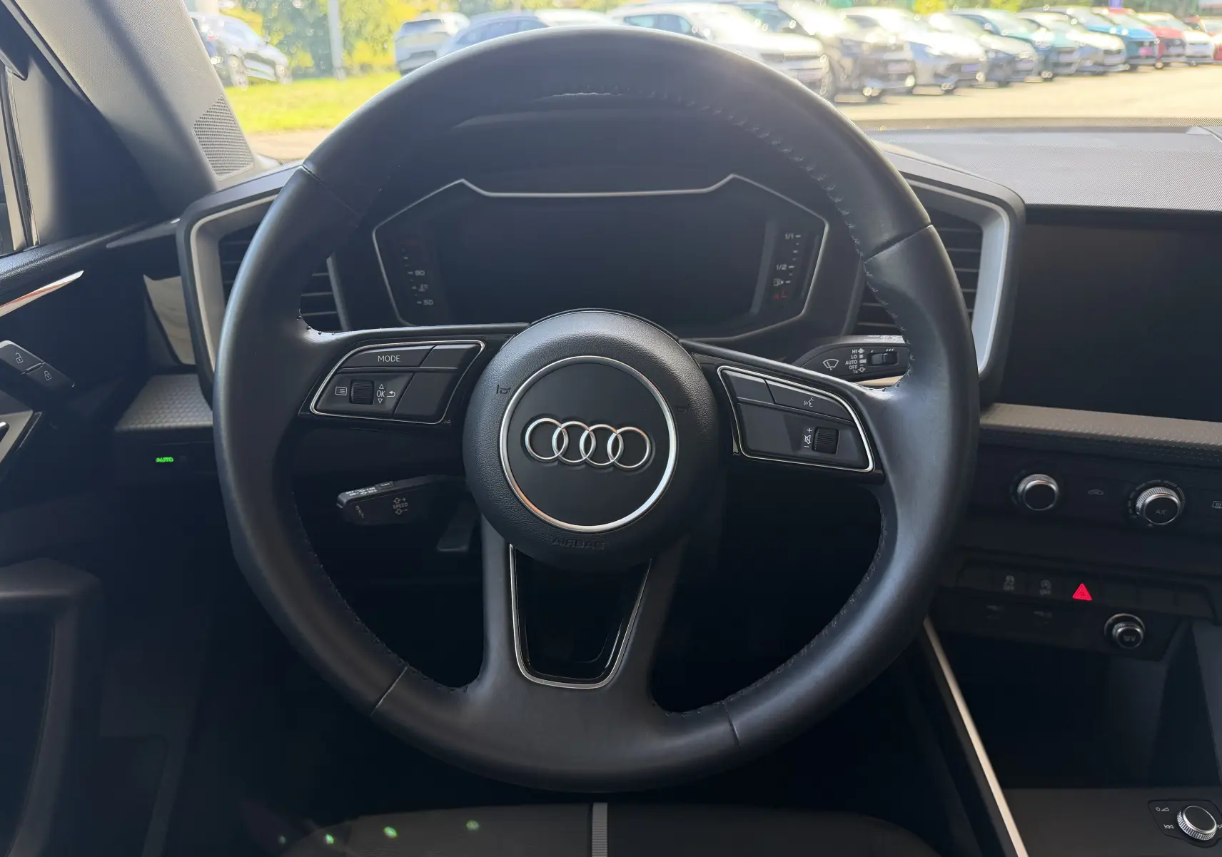 Vue intérieure centrée sur le volant noir de l'Audi A1 Sportback 2020 avec tableau de bord numérique éteint.