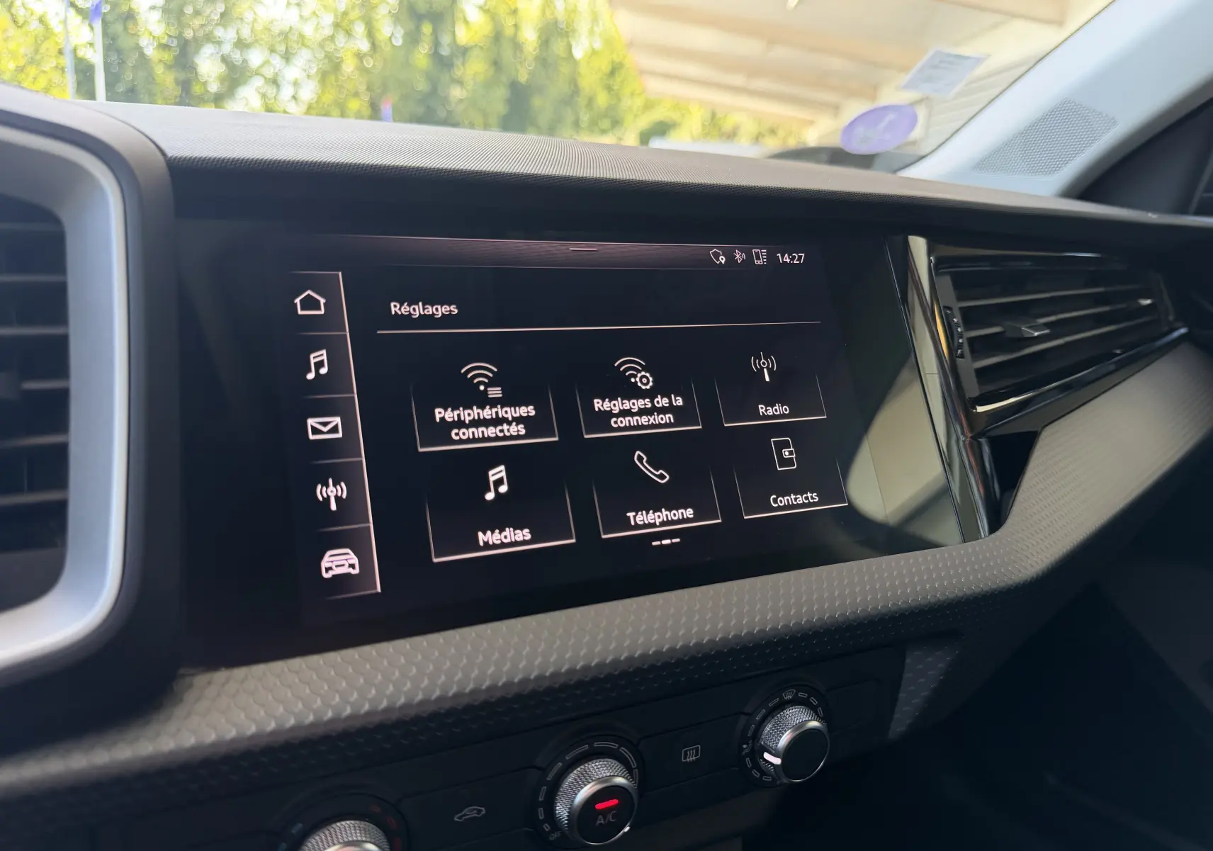 Écran tactile central de l’Audi A1 Sportback 2020 affichant le menu Réglages, avec tableau de bord noir et détails texturés.