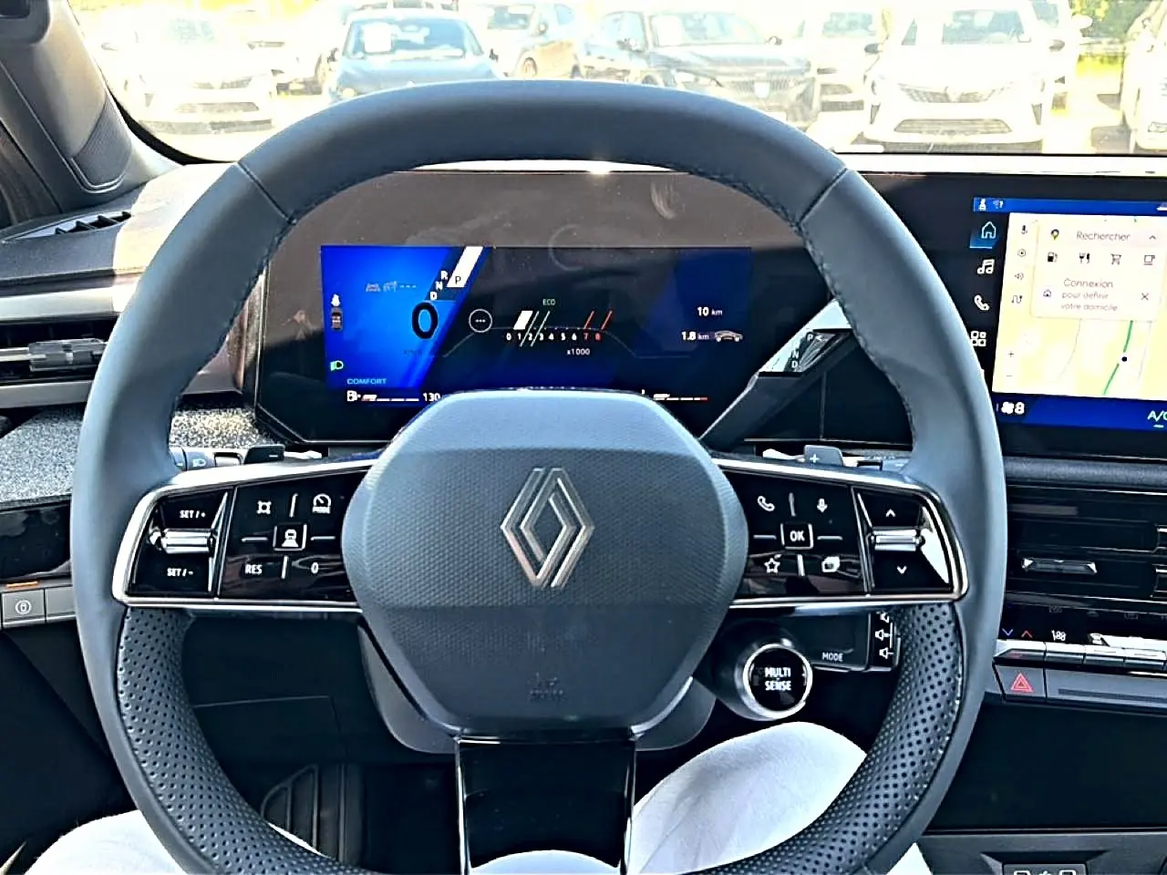 Vue intérieure frontale du volant noir de la Renault Clio VI avec écran numérique et tableau de bord moderne.