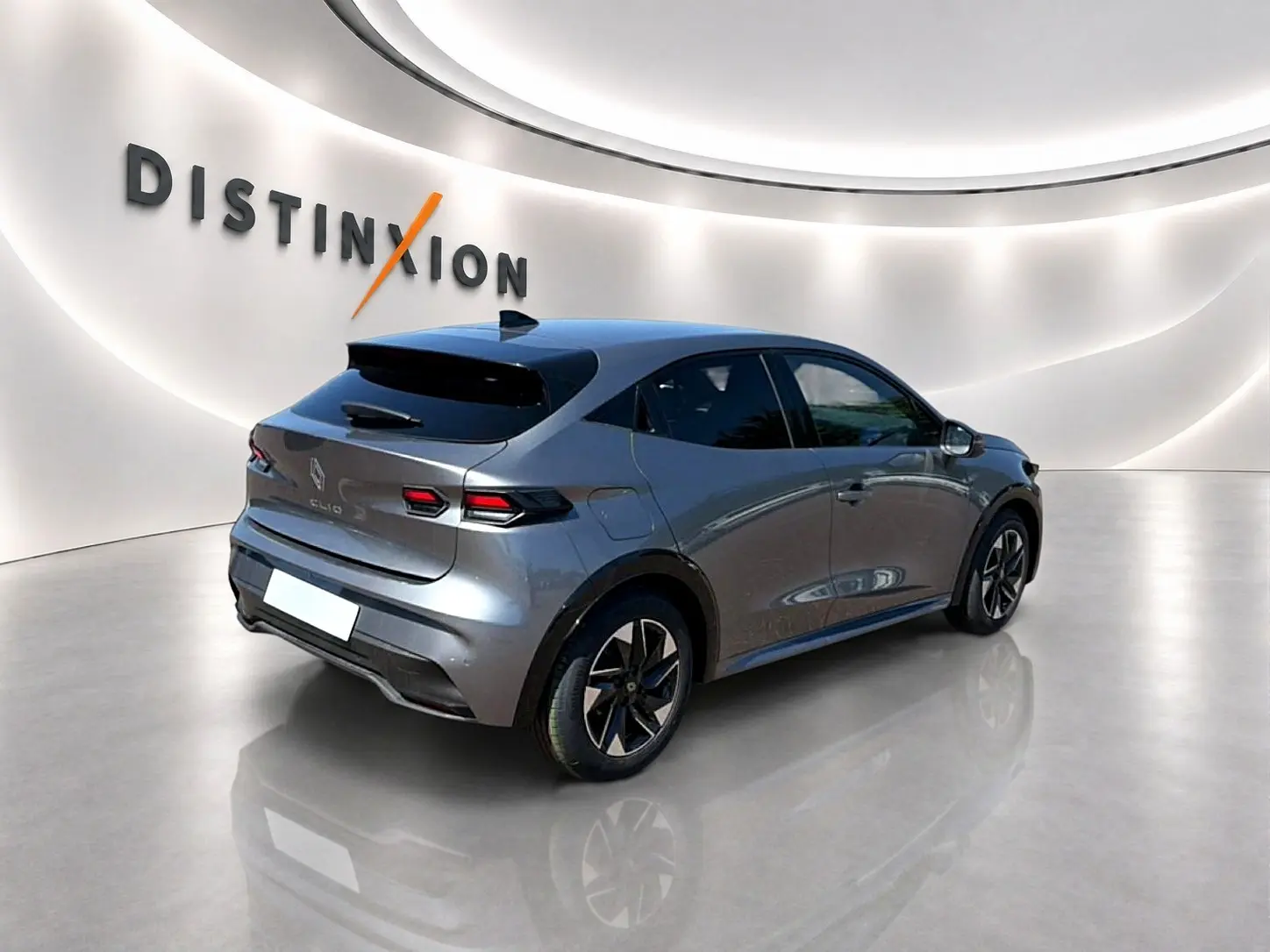 Renault Clio VI gris schiste vue 3/4 arrière droit, avec jantes alu et feux arrière LED distinctifs.