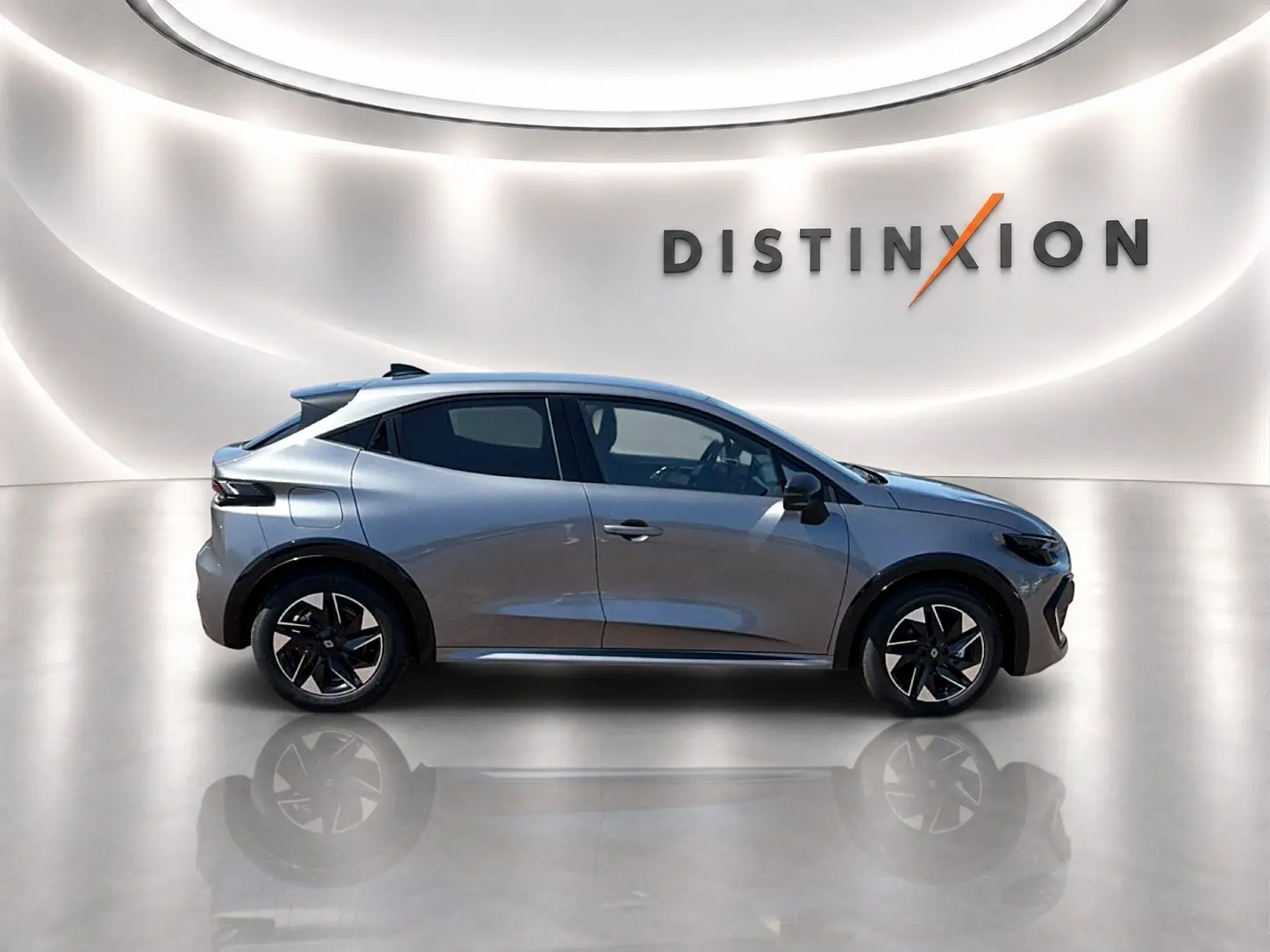 Profil droit de la Renault Clio VI gris schiste 2026 avec jantes alliage et toit noir dans un studio lumineux.