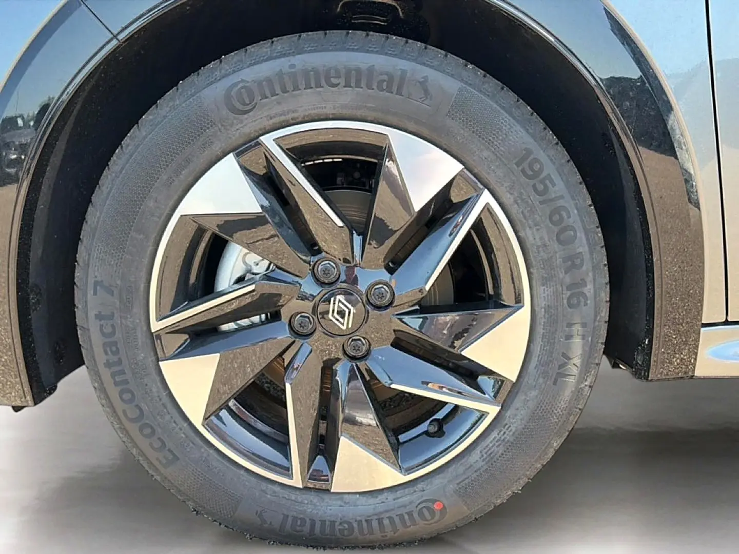 Gros plan sur la roue avant droite de la Renault Clio VI gris schiste avec jante alliage noire et argentée.