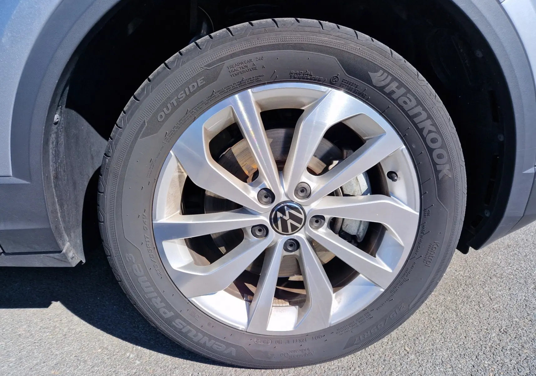Gros plan sur la roue avant gauche d'un Volkswagen T-Roc gris pyrite avec jante alliage et pneu Hankook.