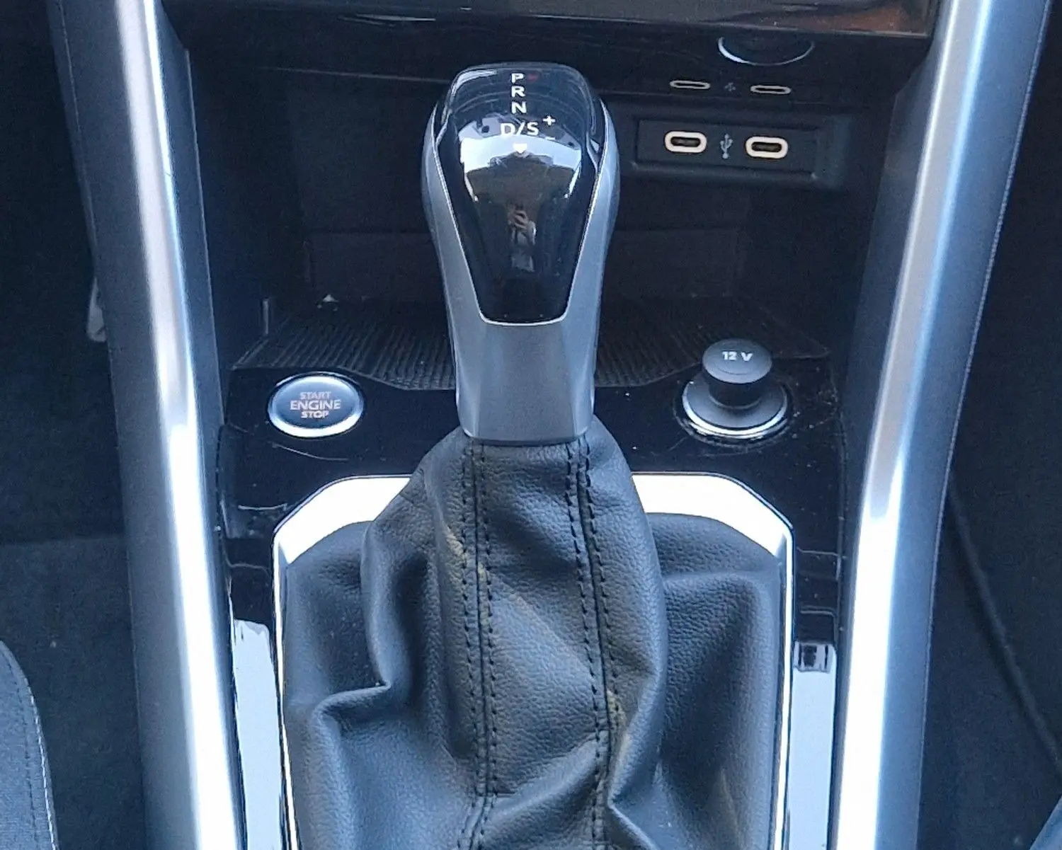 Le levier de vitesses automatique DSG7 du Volkswagen T-Roc 2023, entouré de commandes climatisation et bouton démarrage.