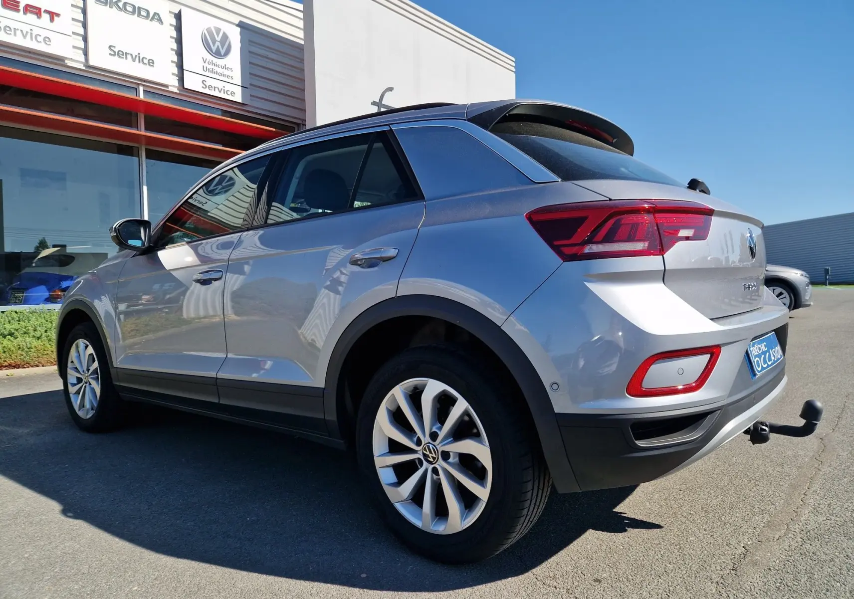 Volkswagen T-Roc gris pyrite en 3/4 arrière droit, avec attelage visible et jantes alliage.