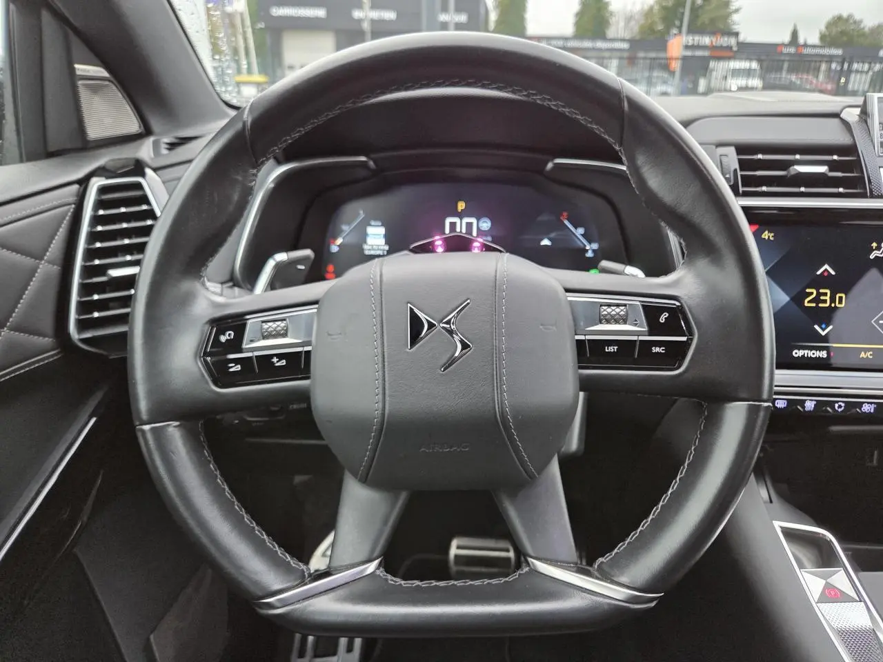Volant cuir noir avec logo DS au centre, tableau de bord numérique et écran tactile du DS7 Crossback 2022 visible en plan rapproché.