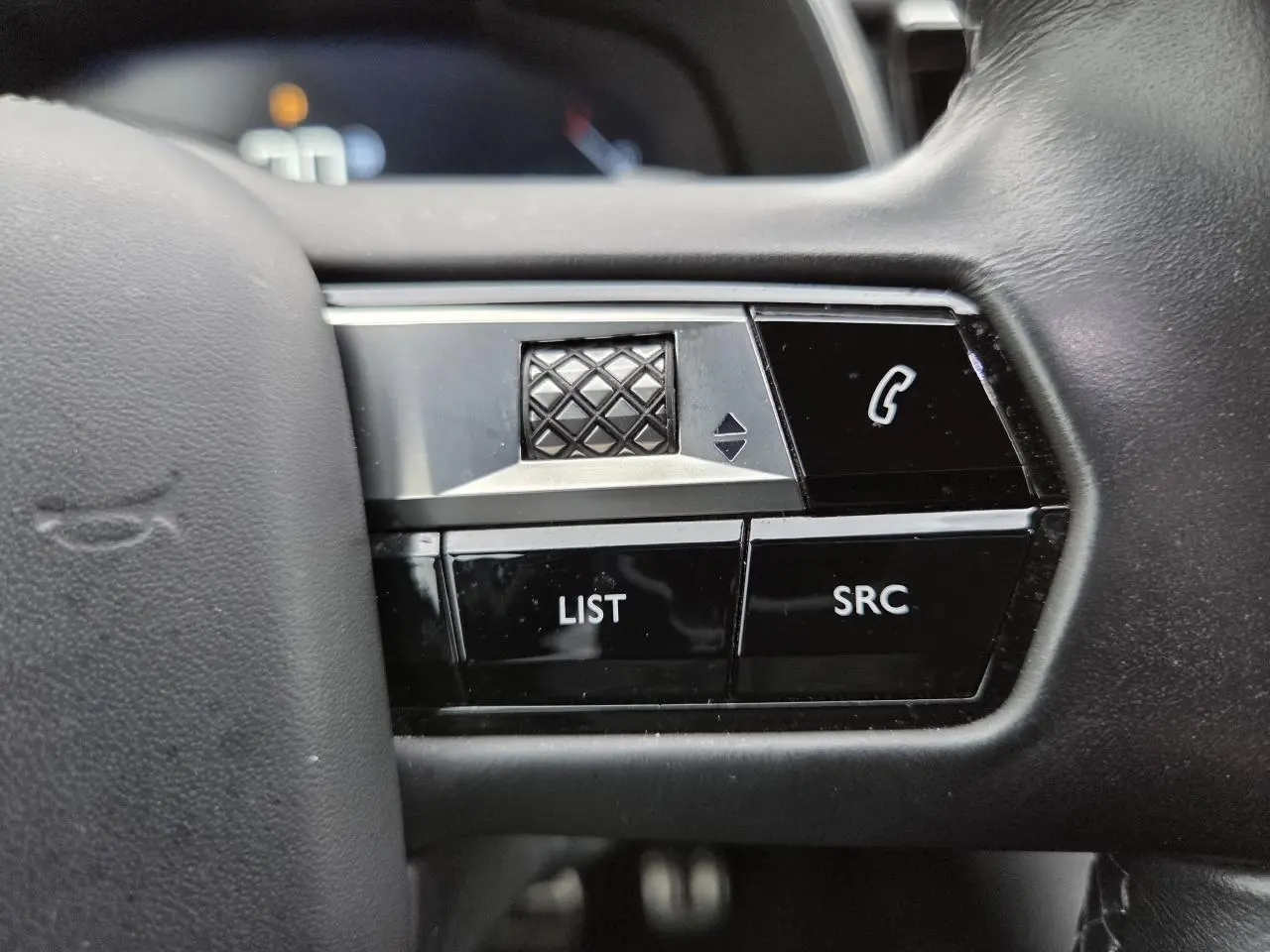 Gros plan sur les commandes noires et argentées du volant cuir du DS7 Crossback noir Perla Metal 2022.