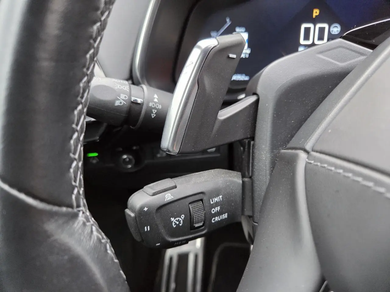 Gros plan sur les commandes au volant en cuir noir du DS7 Crossback 2022 avec palettes de changement de vitesse chrome.