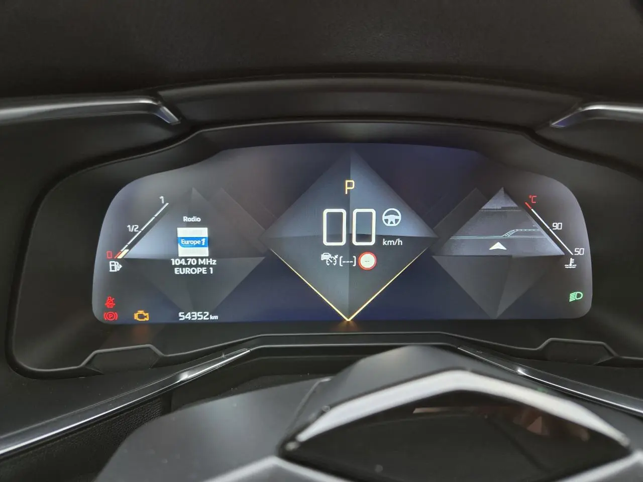 Tableau de bord numérique du DS7 Crossback 2022 affichant la vitesse, la radio et les indicateurs, vue frontale rapprochée.