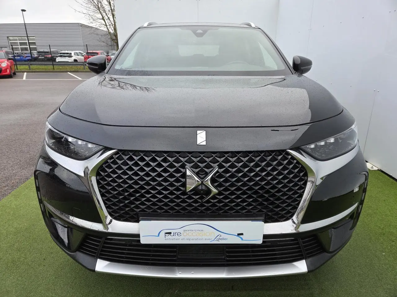 Vue de face d'un DS7 Crossback noir Perla Metal avec calandre noire à motif losange et logo DS central chromé.