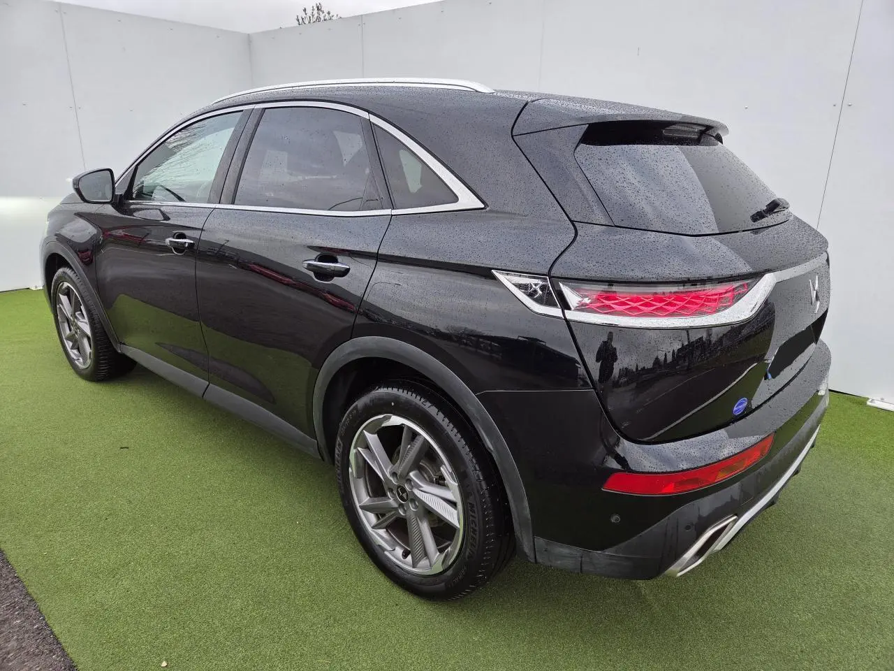 Vue 3/4 arrière droite du DS7 Crossback noir Perla Metal avec feux arrière 3D et jantes alliage 19 pouces Roma.