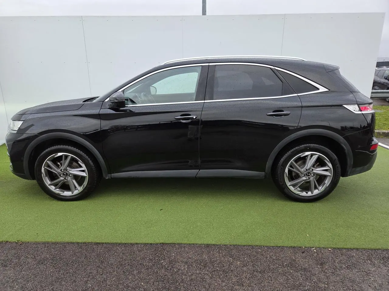 Profil droit du DS7 Crossback noir Perla Metal avec jantes alliage 19 pouces et vitres surteintées.