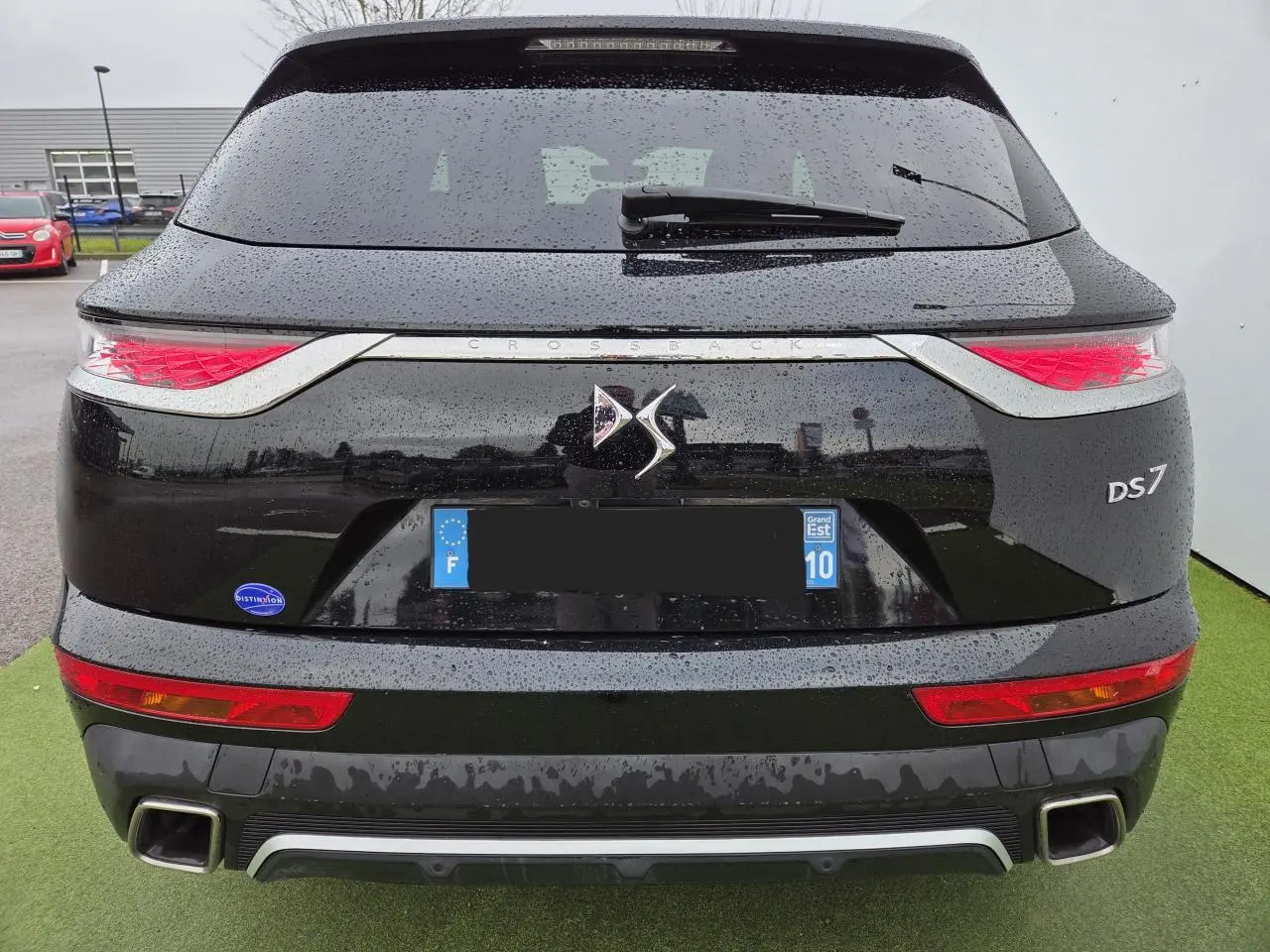 Vue arrière d'un DS7 Crossback noir perla metal avec feux arrière 3D et double sortie d'échappement carrée.