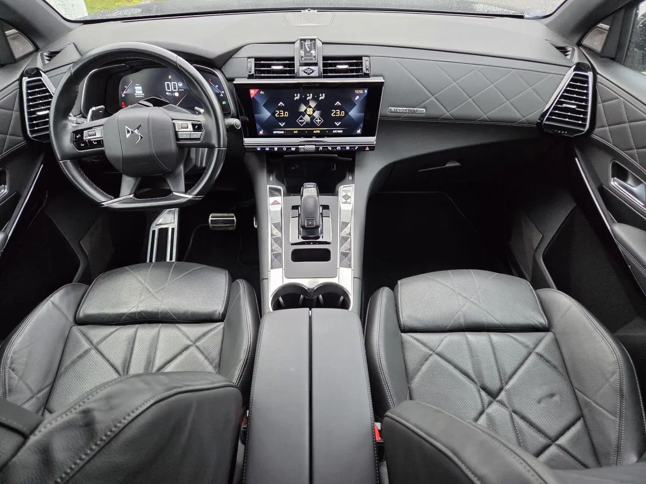 Vue intérieure avant du DS7 Crossback noir Perla Metal avec sièges cuir noir Basalte et tableau de bord guilloché Clous de Paris.
