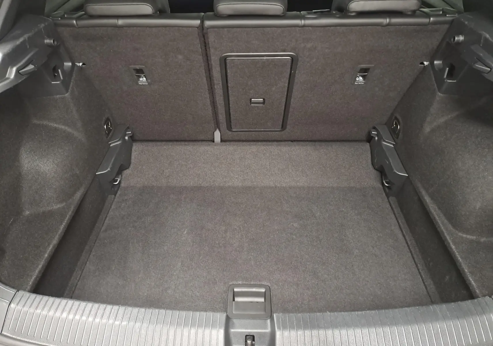 Coffre ouvert du Volkswagen T-Roc 1.5 TSI 150 DSG7 R-Line Edition, vue intérieure montrant l'espace de chargement gris.