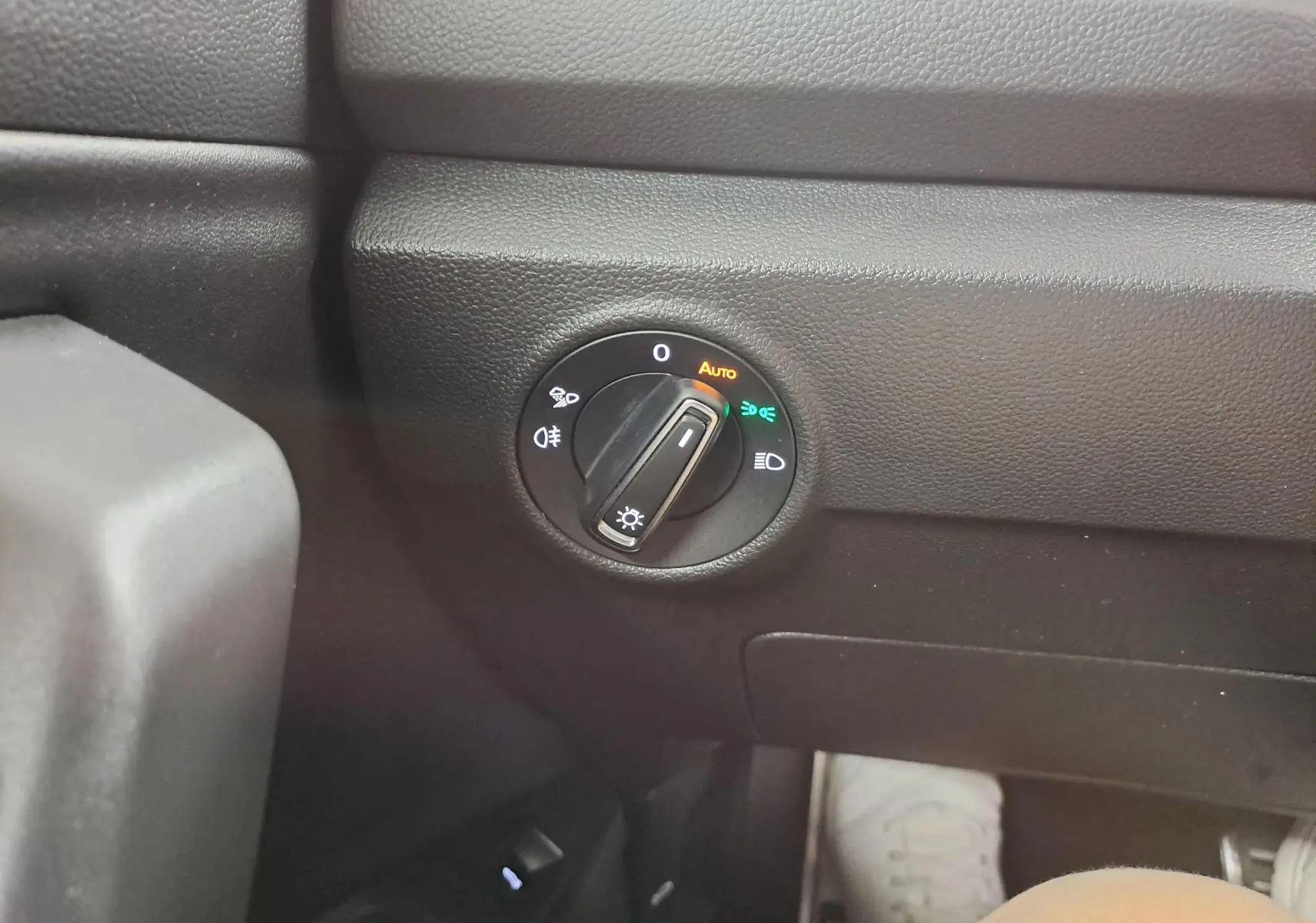 Gros plan sur le sélecteur d’éclairage noir du tableau de bord intérieur du Volkswagen T-Roc gris pyrite.