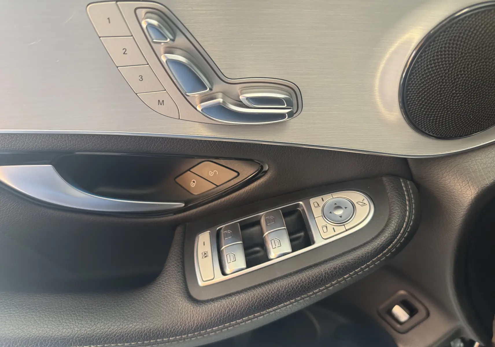 Détail de la porte côté conducteur du Mercedes GLC Coupé noir 2018, avec commandes de sièges et vitres en aluminium brossé.