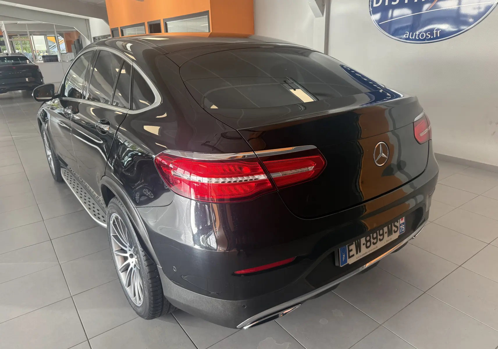Vue 3/4 arrière droite d'un Mercedes GLC Coupé noir 2018, finition Sportline AMG avec feux arrière LED et jantes alliage.