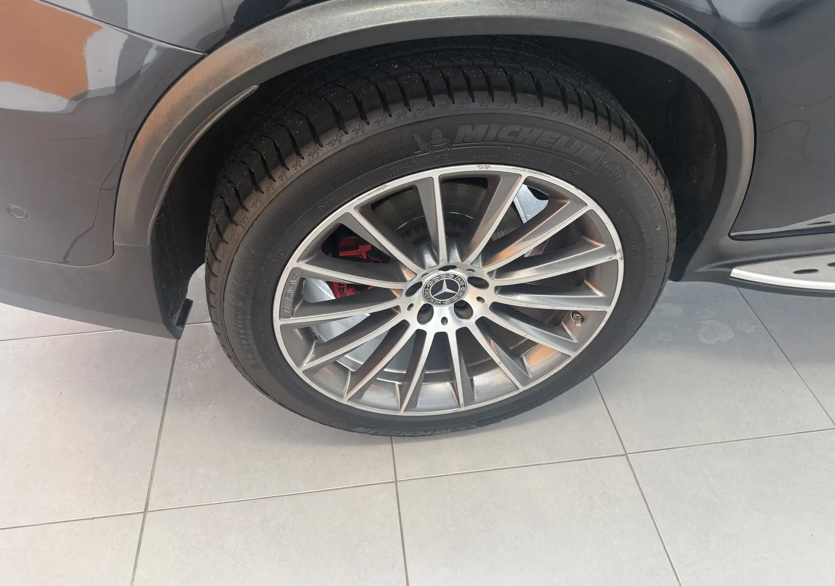 Gros plan sur la roue avant gauche du Mercedes GLC Coupé noir, avec jante AMG et étrier de frein rouge visible.