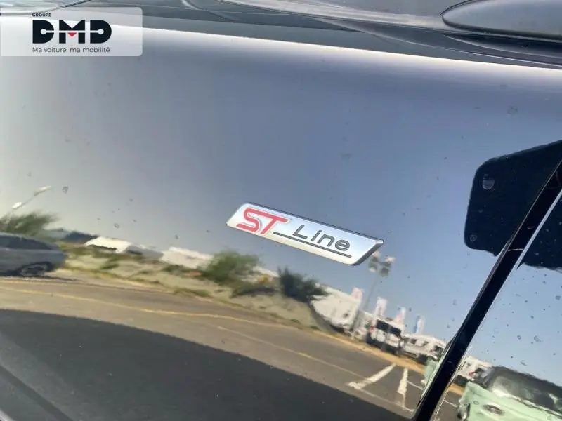 Gros plan sur l’écusson ST-Line sur la porte côté gauche d’un Ford Puma noir agate métallisé.