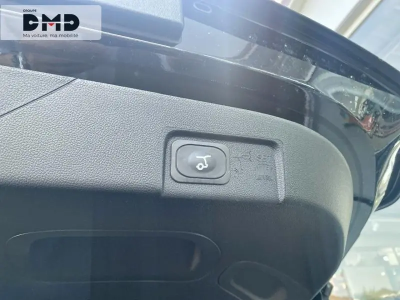 Bouton d'ouverture électrique du coffre sur la partie intérieure du hayon d'un Ford Puma noir Agate Métallisée.