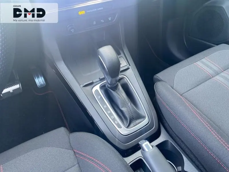 Gros plan sur la console centrale avec levier de boîte auto et sièges sport noirs avec surpiqûres rouges du Ford Puma 2026.