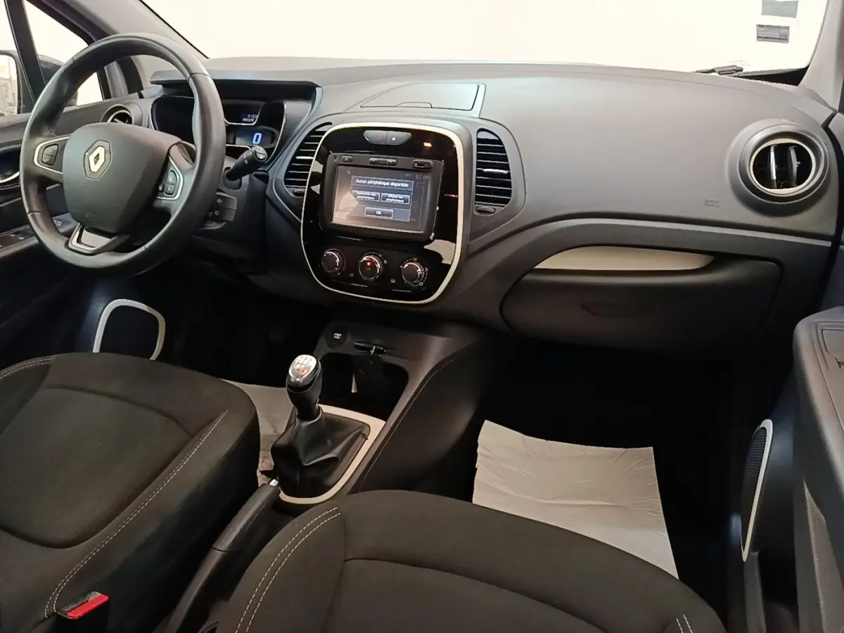 Vue intérieure avant droite du Renault Captur Zen TCe 90 2018, tableau de bord gris avec écran tactile et boîte manuelle.