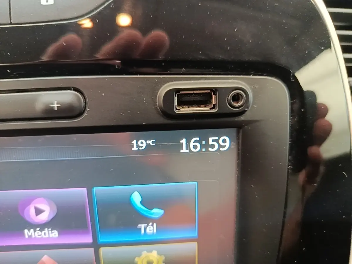Gros plan sur l’écran tactile multimédia noir du Renault Captur gris clair, affichant l’heure et la température extérieure.