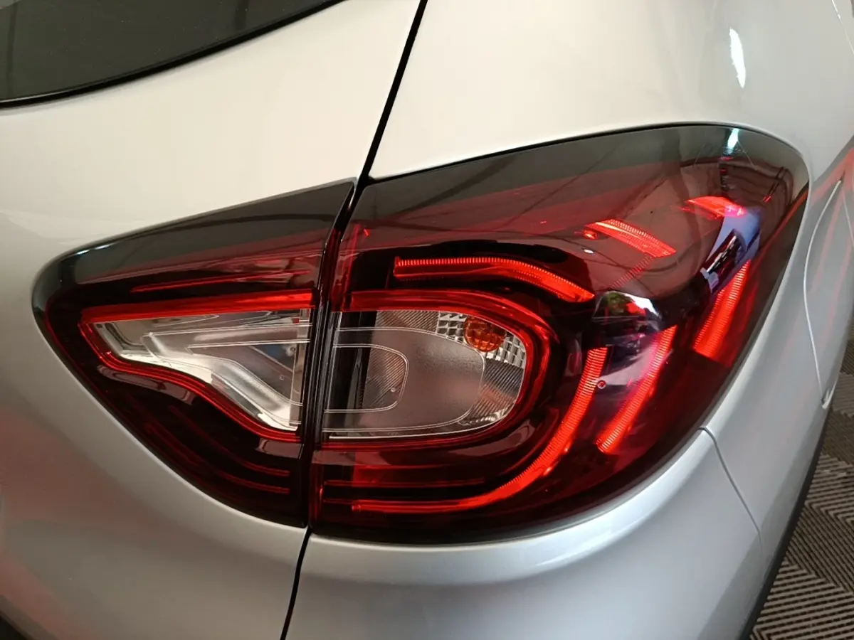 Gros plan sur le feu arrière droit rouge et blanc du Renault Captur gris clair, version 2018 Zen TCe 90.