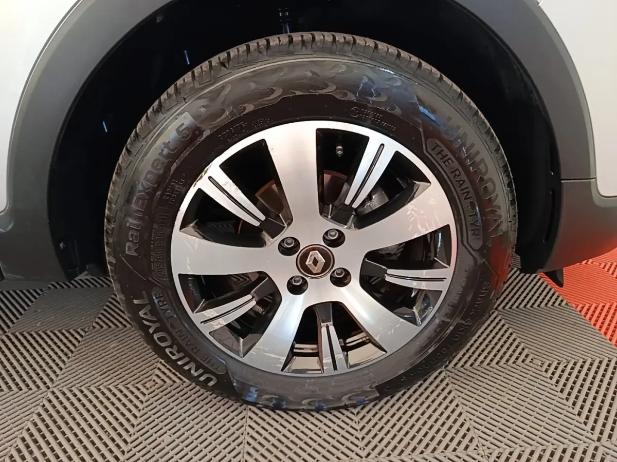 Gros plan sur la roue avant droite du Renault Captur gris clair, mettant en valeur la jante alliage et le pneu Uniroyal.