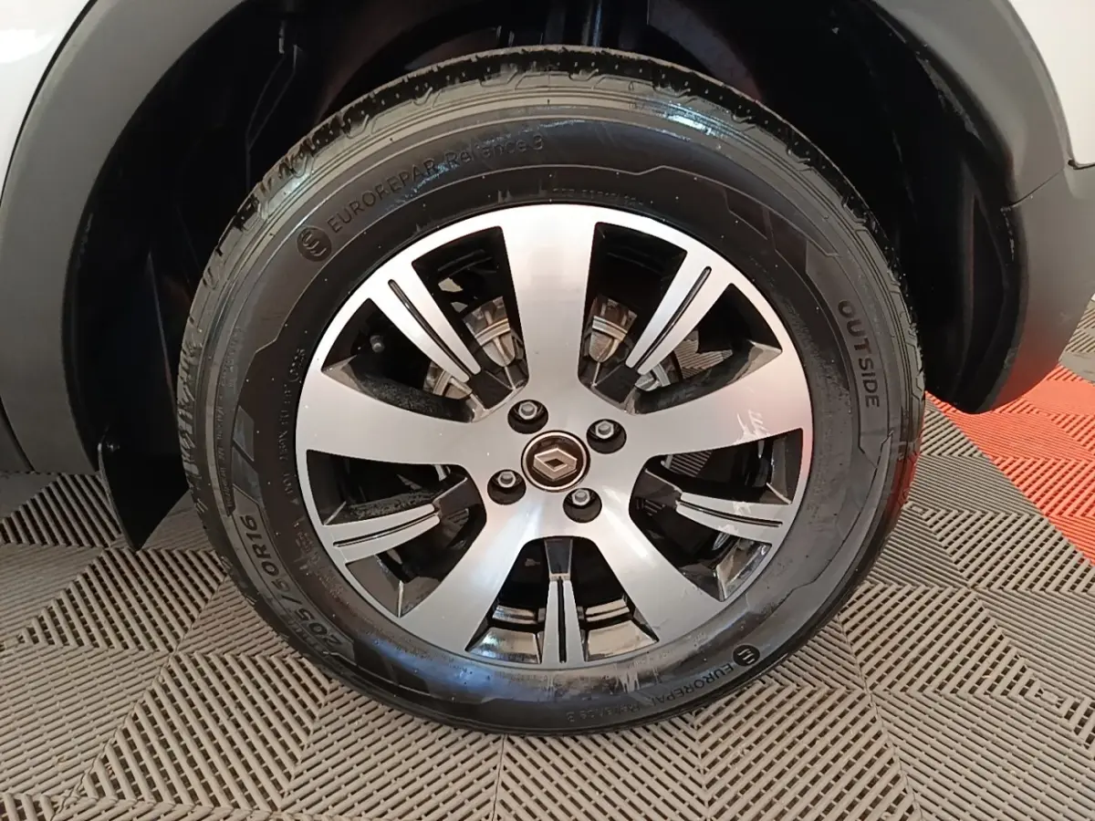 Gros plan sur la roue avant droite du Renault Captur gris clair, mettant en valeur la jante alliage et le pneu.