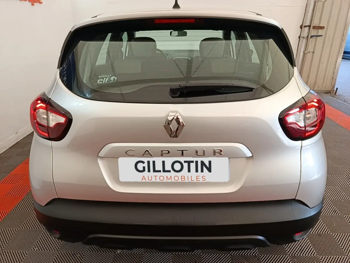 Vue arrière d'un Renault Captur gris clair de 2018 avec feux arrière LED et logo Renault bien visible.