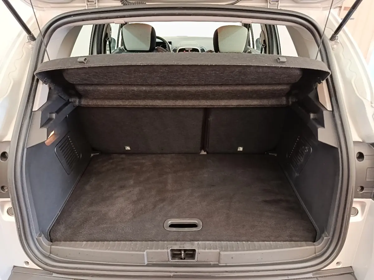 Coffre ouvert d’un Renault Captur gris clair 2018, vue arrière montrant l’espace de chargement et la tablette amovible.