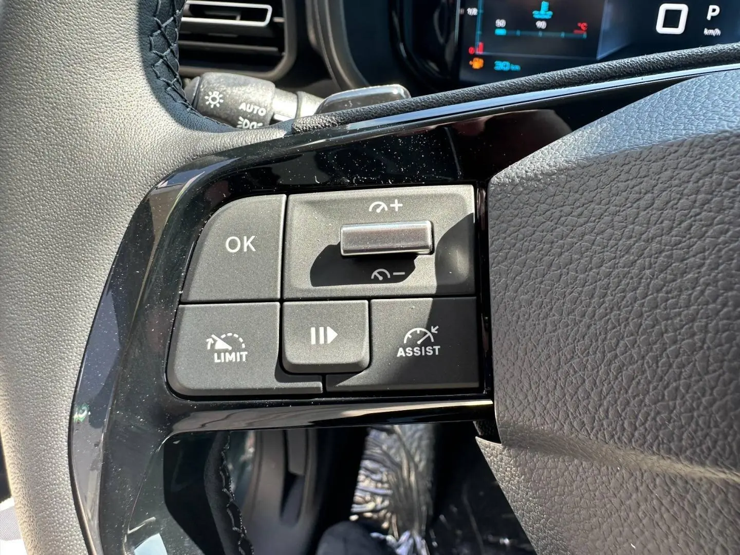 Gros plan sur les commandes multifonctions à gauche du volant cuir du Citroën Berlingo 2026 Kiama Blue.