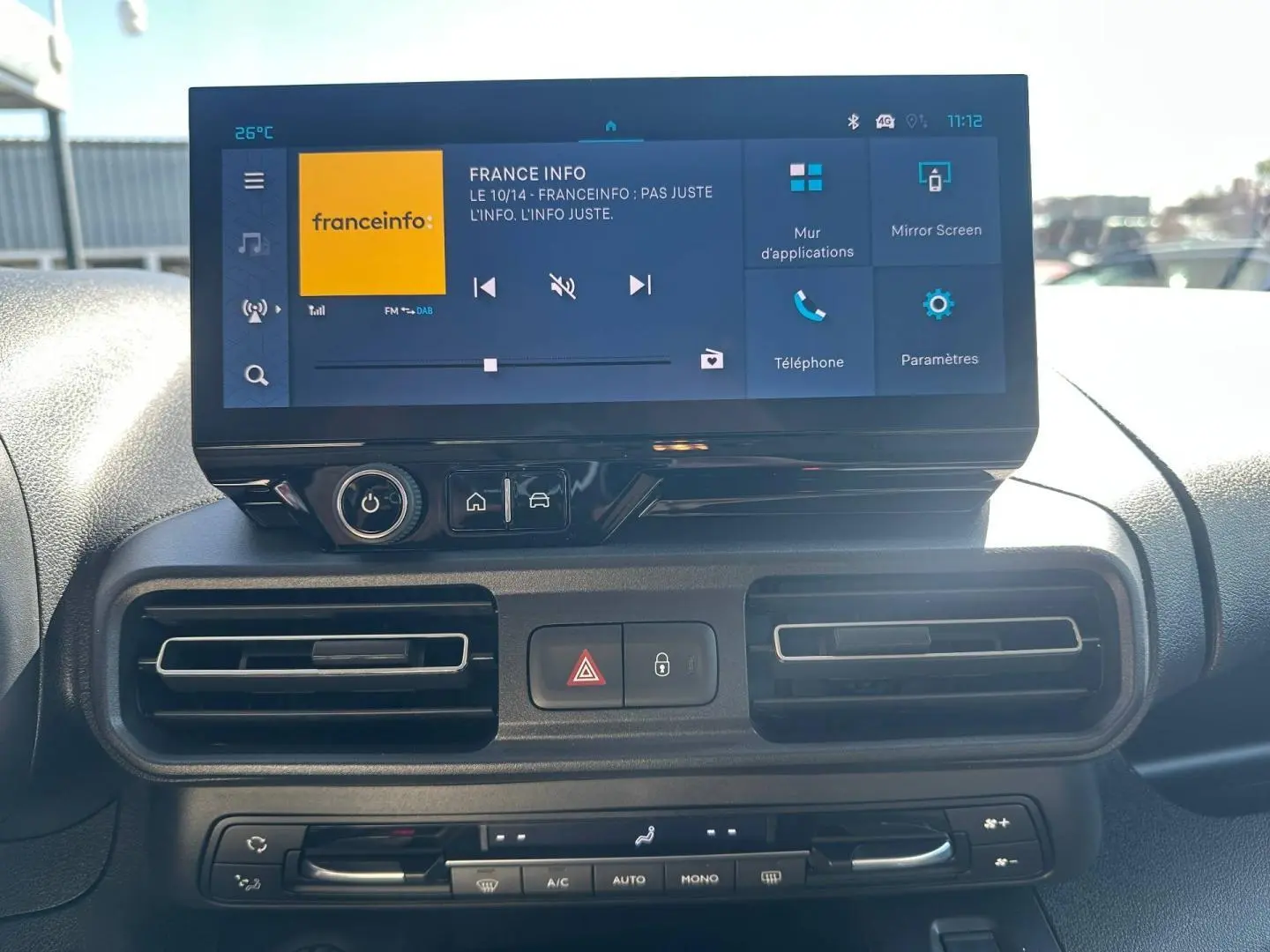 Tableau de bord du Citroën Berlingo 2026 avec écran tactile multifonction et commandes de climatisation en vue frontale rapprochée.