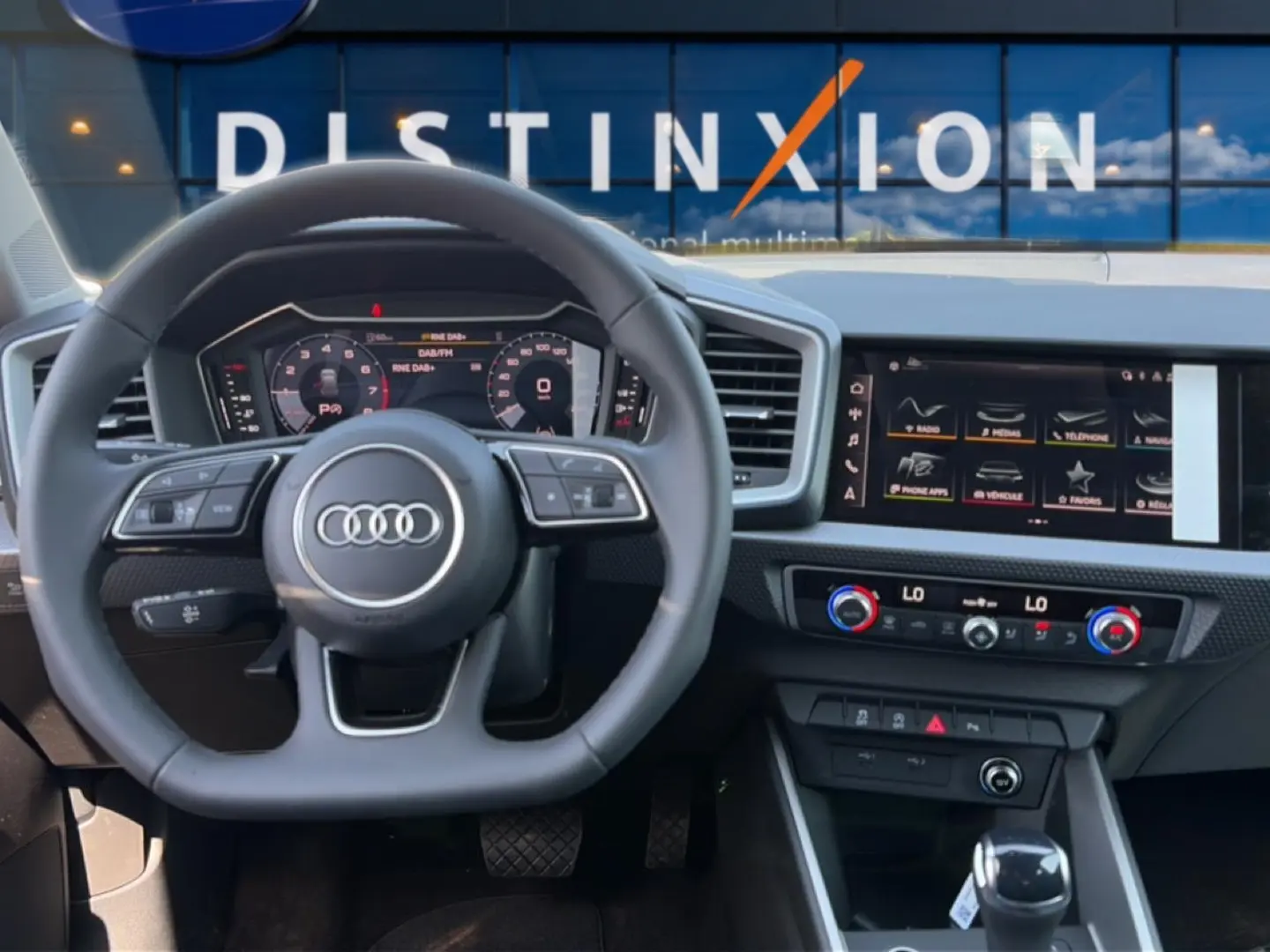 Vue intérieure du poste de conduite de l'Audi A1 Sportback 30 TFSI 116 S line 2026 avec volant cuir et écran tactile.