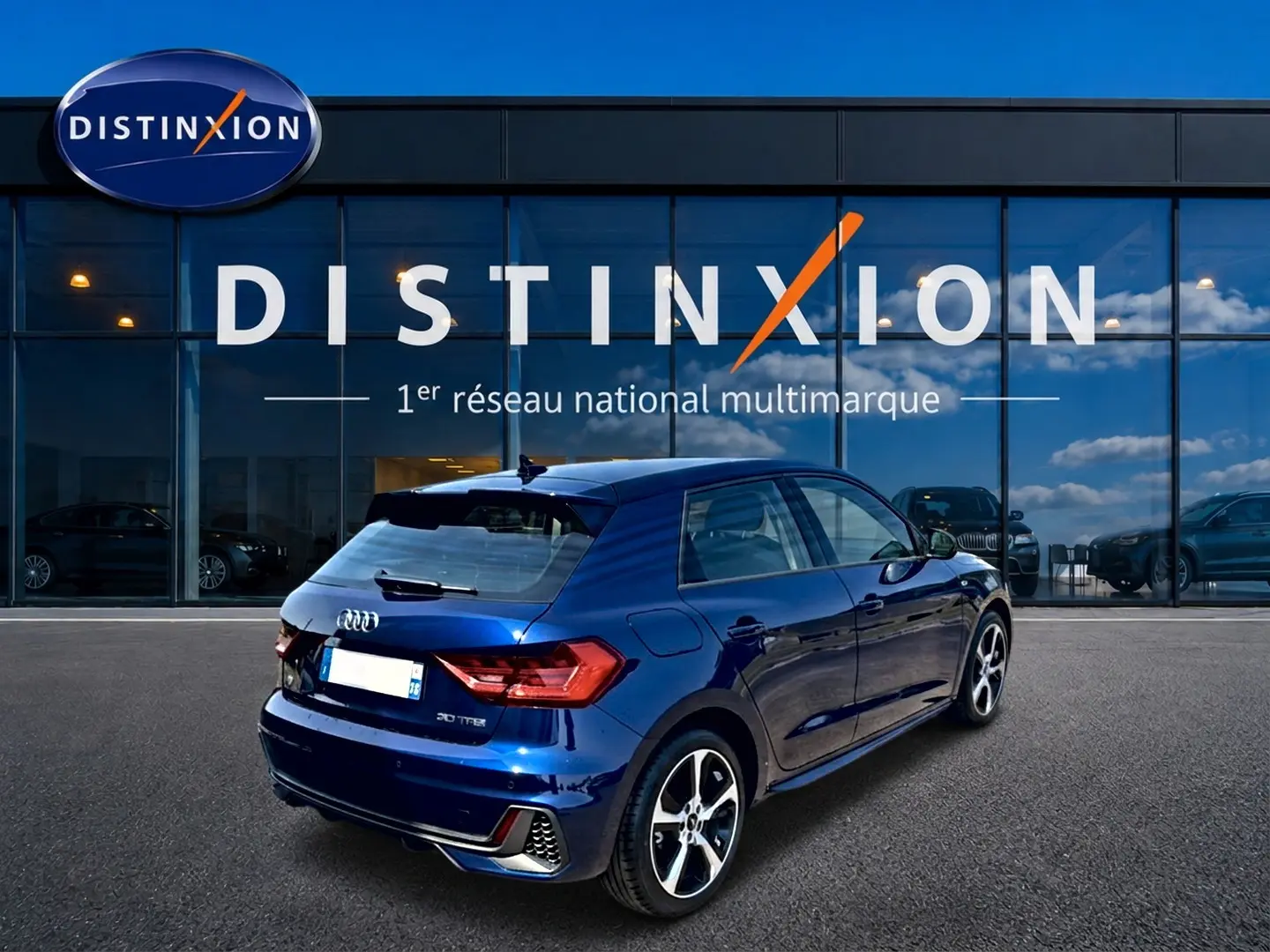 Audi A1 Sportback bleu foncé vue 3/4 arrière droit, avec jantes alliage et becquet arrière noir.
