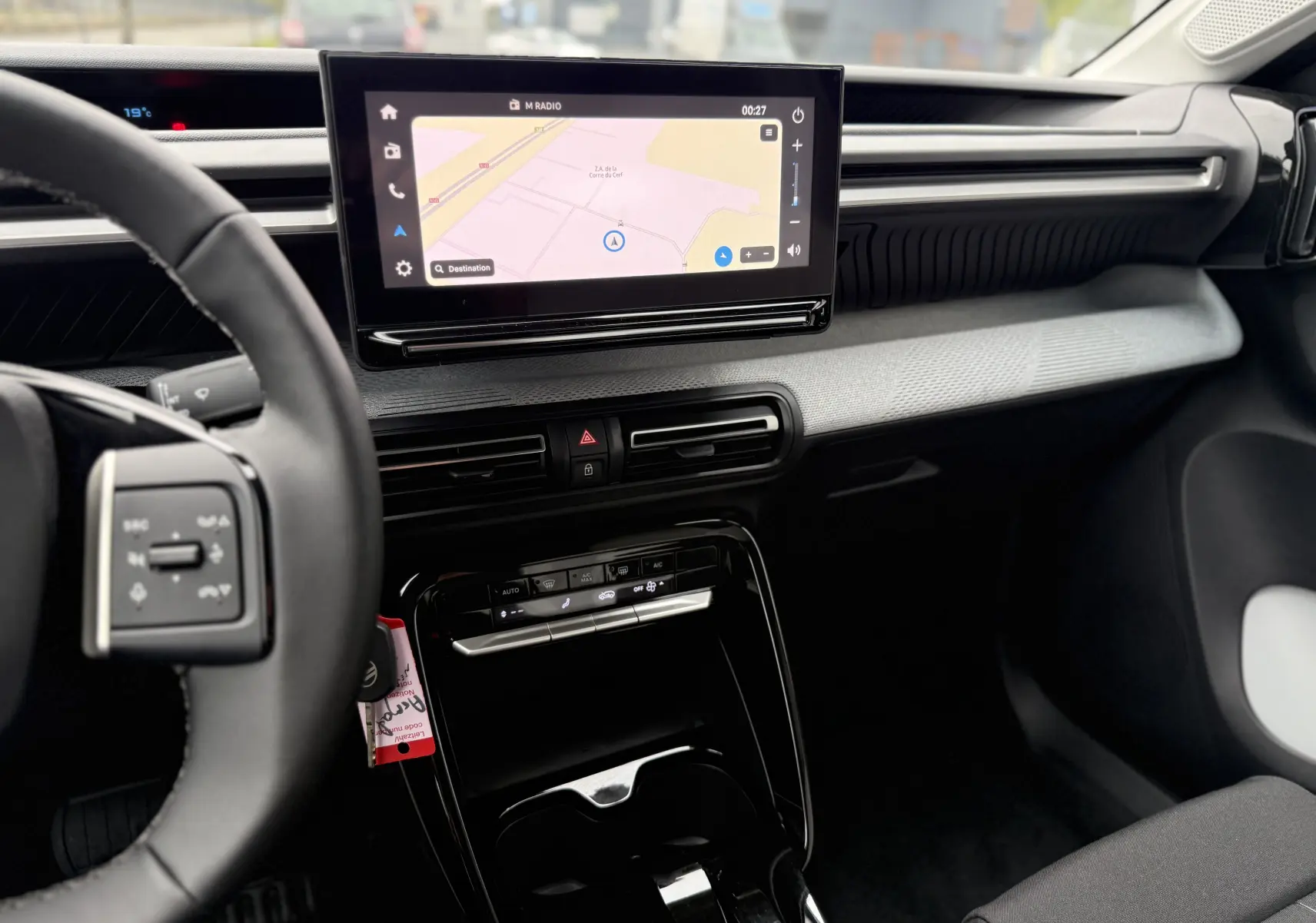 Vue intérieure côté conducteur du tableau de bord de la Citroën C3 hybride 2026 avec écran tactile et commandes de climatisation.