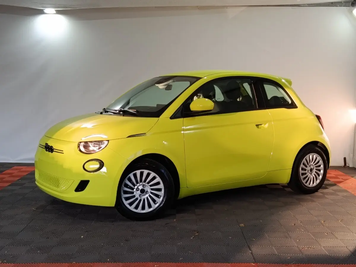 Vue de profil droit d'une FIAT 500 électrique jaune vif avec jantes argentées dans un studio.